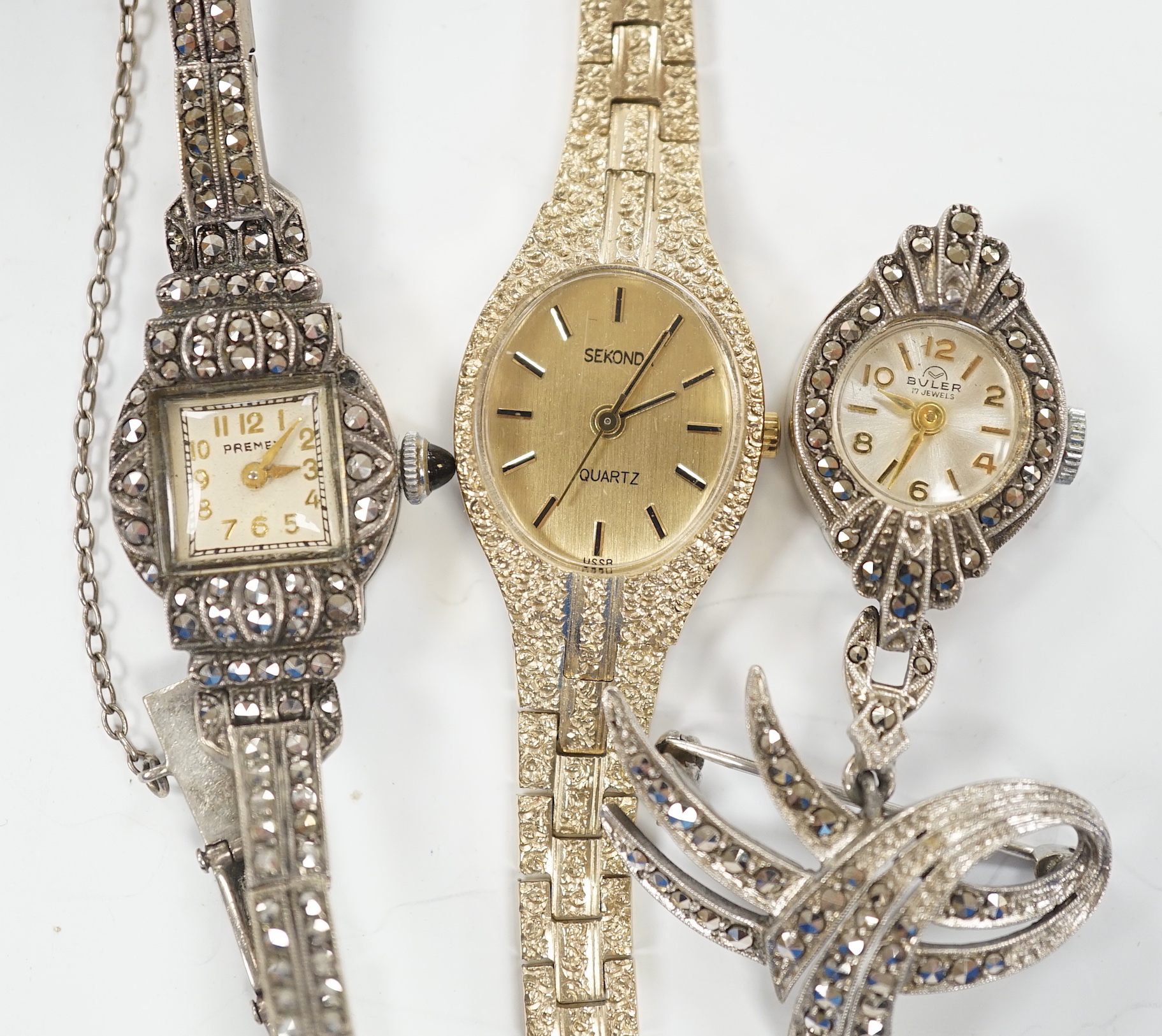 A late 1950's silver and marcasite set Premex manual wind cocktail watch, a similar lapel watch and a lady's Sekonda quartz watch.